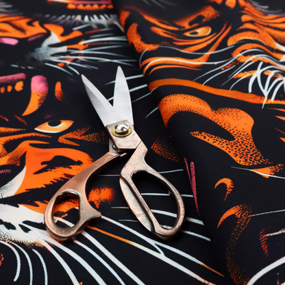 A dark patterned fabric featuring an aggressive, repeated motif of roaring tigers with bared fangs, detailed in vibrant orange, white, and pink against a black background.   