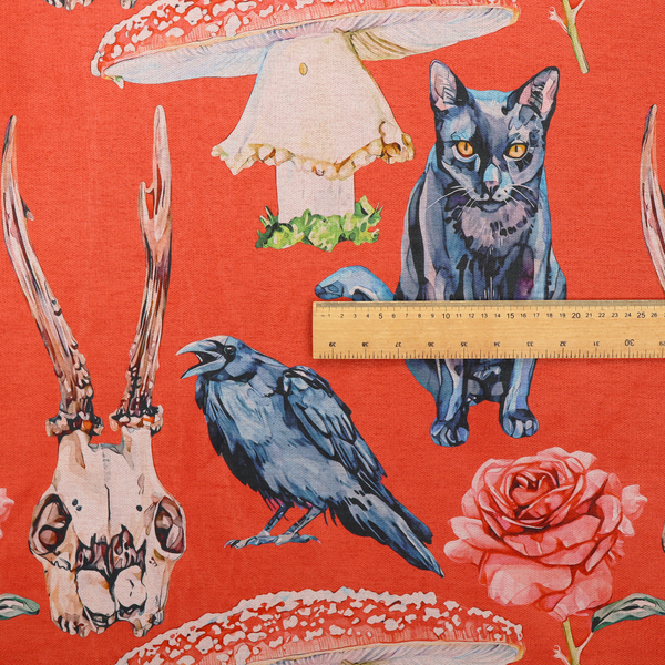 A red fabric patterned with hand-drawn gothic illustrations of black cats, crows, animal skulls, mushrooms, and roses featuring an organic style.