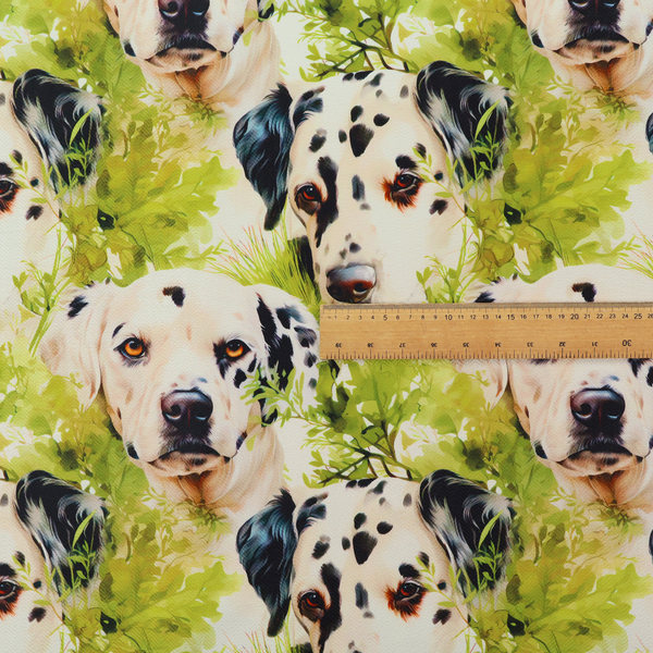 A green and white fabric patterned with hand-drawn illustrations of Dalmatians nestled among lush foliage featuring an organic style.