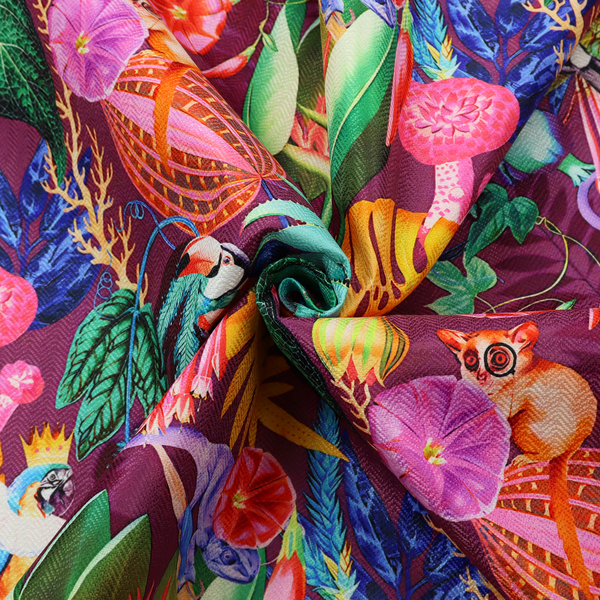 A burgundy fabric patterned with hand-drawn jungle illustrations of toucans, tarsiers, colourful birds, and tropical foliage featuring an organic style.   
