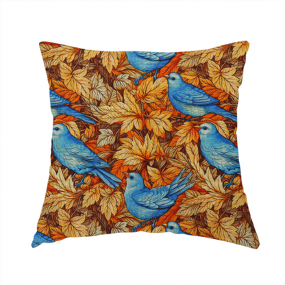 The fabric used to create this handmade cushion is an orange and brown fabric patterned with hand-drawn botanical illustrations of blue birds perched amongst fall leaves featuring an organic style.   

