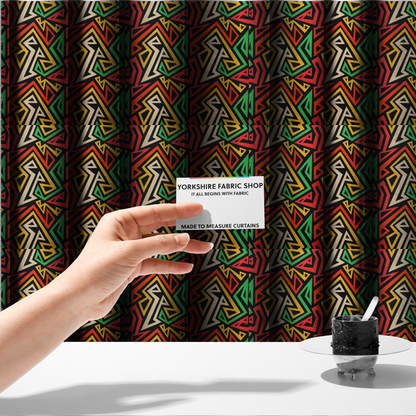 The fabric sued to create these made-to-measure curtains is a repeating geometric fabric pattern on a black background featuring interlocking angular lines in red, yellow, green, and beige.