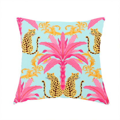 The fabric used to create this handmade cushion is a vibrant fabric pattern featuring repeating pairs of leopards, bright pink palm trees, and gold baroque scrollwork against a light blue background.