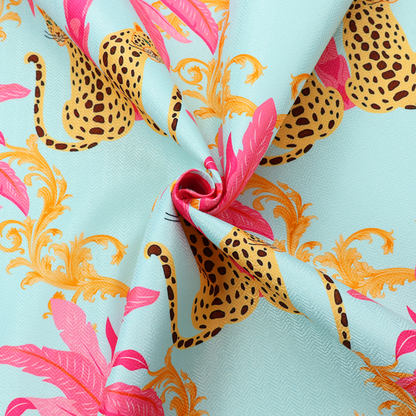 A vibrant fabric pattern featuring repeating pairs of leopards, bright pink palm trees, and gold baroque scrollwork against a light blue background.