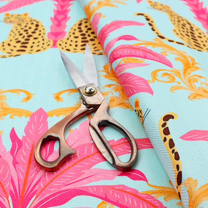 A vibrant fabric pattern featuring repeating pairs of leopards, bright pink palm trees, and gold baroque scrollwork against a light blue background.