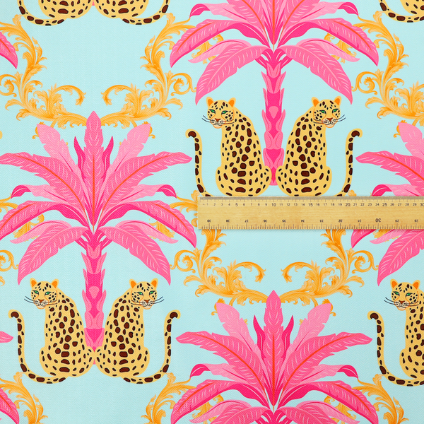 A vibrant fabric pattern featuring repeating pairs of leopards, bright pink palm trees, and gold baroque scrollwork against a light blue background.