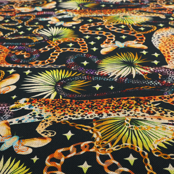 A dark blue fabric patterned with hand-drawn jungle illustrations of leopards, golden chains, tropical leaves, and butterflies featuring an organic style.   