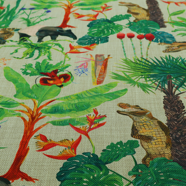 A green and beige fabric patterned with hand-drawn jungle illustrations of alligators, a tapir, tropical trees, and vibrant flowers featuring an organic style.