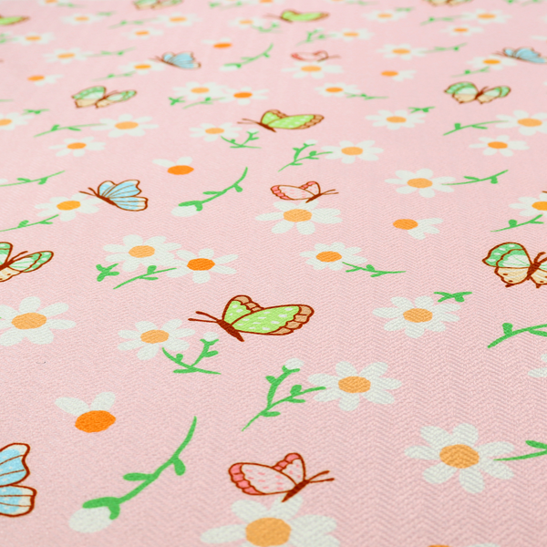 Pink fabric featuring a charming spring pattern with white daisies, green stems, and colourful butterflies in blue, green, and orange scattered across the surface.   