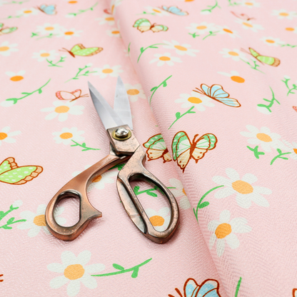 Pink fabric featuring a charming spring pattern with white daisies, green stems, and colourful butterflies in blue, green, and orange scattered across the surface.   