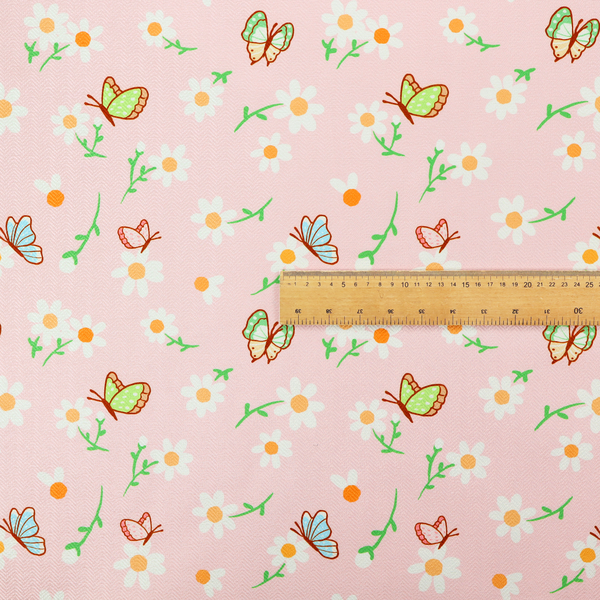 Pink fabric featuring a charming spring pattern with white daisies, green stems, and colourful butterflies in blue, green, and orange scattered across the surface.   