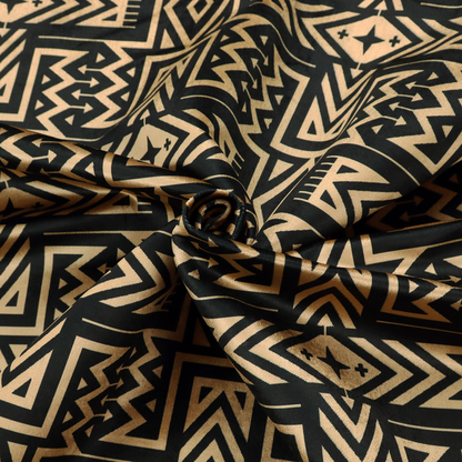 Black and gold geometric fabric featuring an intricate Navajo-inspired tribal pattern with chevron lines, diamonds, and cross motifs.