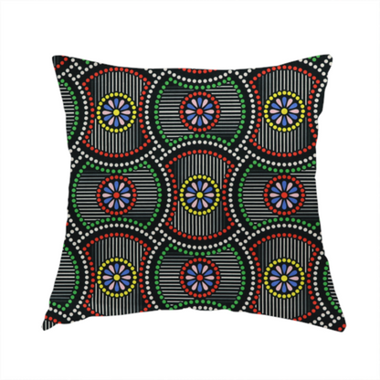 The fabric used to create this handmade cushion is a vibrant multi-coloured fabric featuring a detailed dotted pattern with concentric circular motifs, floral-like centre rosettes, and striped geometric panels in black, red, green, blue, and yellow.   