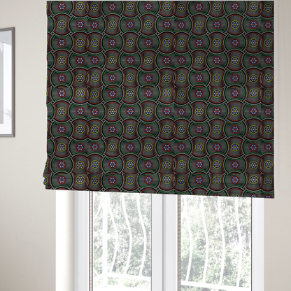 The fabric used to create these Roman blinds is a vibrant multi-coloured fabric featuring a detailed dotted pattern with concentric circular motifs, floral-like centre rosettes, and striped geometric panels in black, red, green, blue, and yellow.   