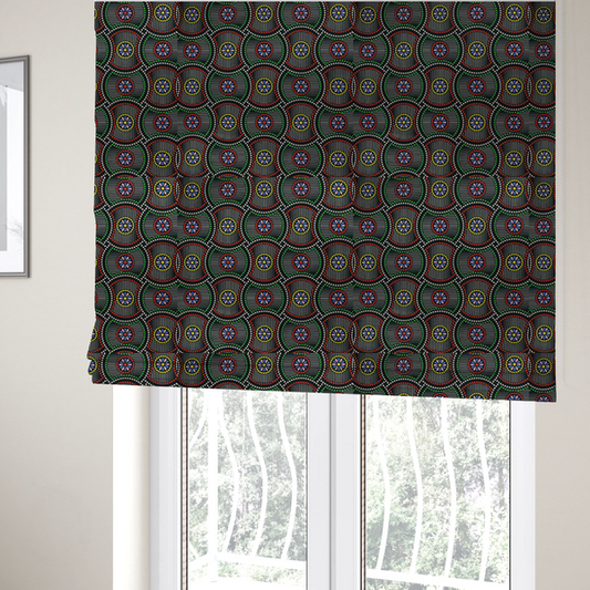 The fabric used to create these Roman blinds is a vibrant multi-coloured fabric featuring a detailed dotted pattern with concentric circular motifs, floral-like centre rosettes, and striped geometric panels in black, red, green, blue, and yellow.   