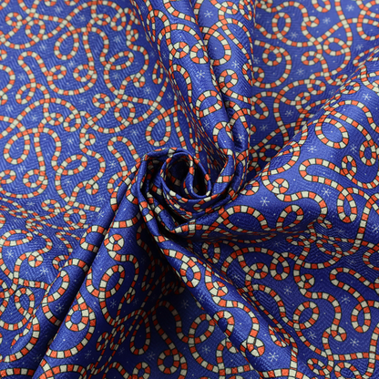 Blue and red fabric featuring an intricate festive pattern with continuous wiggly candy cane lines and tiny white snowflakes scattered across the deep blue background.   