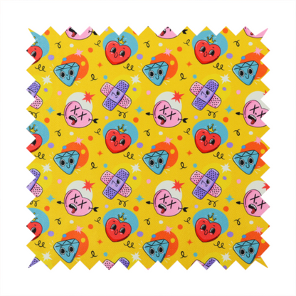 Yellow fabric featuring a playful, quirky pattern with cartoon-style graphics including smiling hearts with crowns, cute diamonds, cartoon bandages, and wacky faces with X eyes on a bright yellow background.   