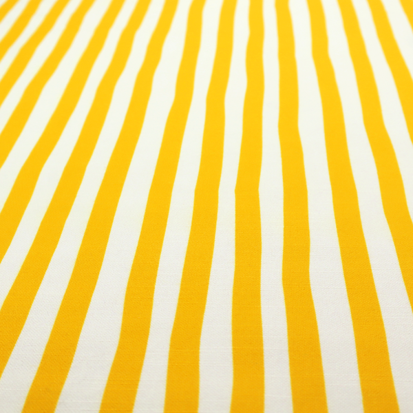A white fabric patterned with vertical, hand-drawn yellow stripes that feature a slight, organic waviness.   
