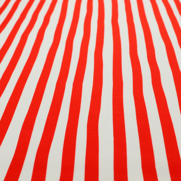 A white fabric patterned with vertical, hand-drawn red stripes that feature a slight, organic waviness.