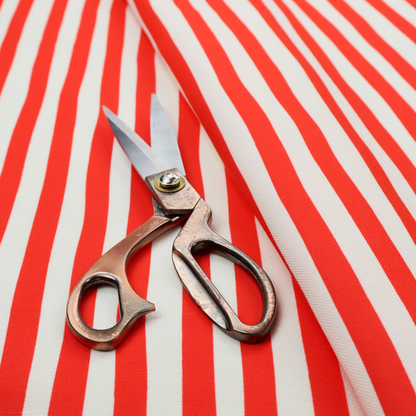 A white fabric patterned with vertical, hand-drawn red stripes that feature a slight, organic waviness.