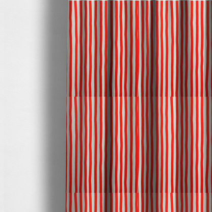 The fabric used to create these made-to-measure curtains is a white fabric patterned with vertical, hand-drawn red stripes that feature a slight, organic waviness.