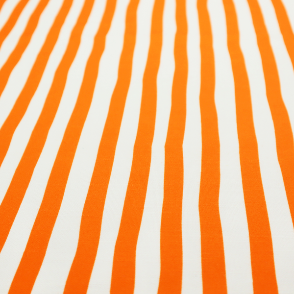A white fabric patterned with vertical, hand-drawn orange stripes that feature a slight, organic waviness.