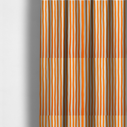 The fabric used to create these made-to-measure curtains is a white fabric patterned with vertical, hand-drawn orange stripes that feature a slight, organic waviness.