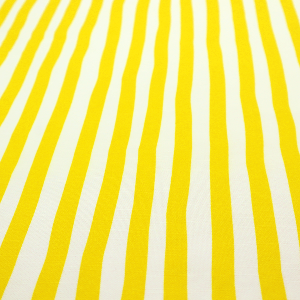 A white fabric patterned with vertical, hand-drawn yellow stripes that feature a slight, organic waviness.