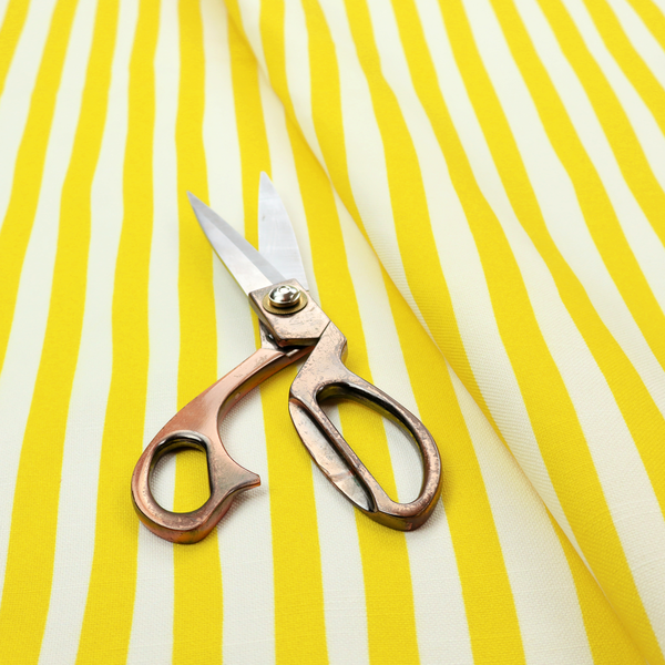 A white fabric patterned with vertical, hand-drawn yellow stripes that feature a slight, organic waviness.