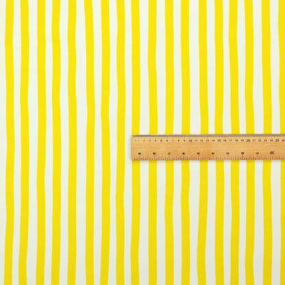 A white fabric patterned with vertical, hand-drawn yellow stripes that feature a slight, organic waviness.