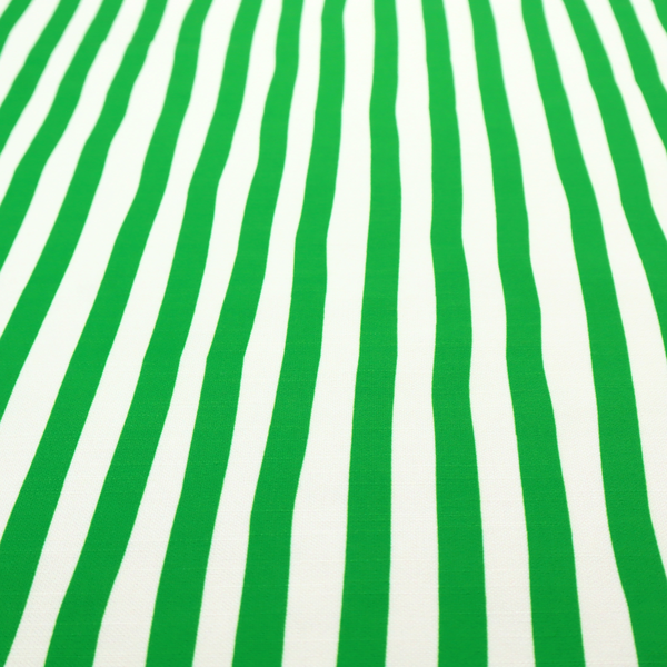 A white fabric patterned with vertical, hand-drawn green stripes that feature a slight, organic waviness.
