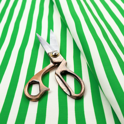 A white fabric patterned with vertical, hand-drawn green stripes that feature a slight, organic waviness.