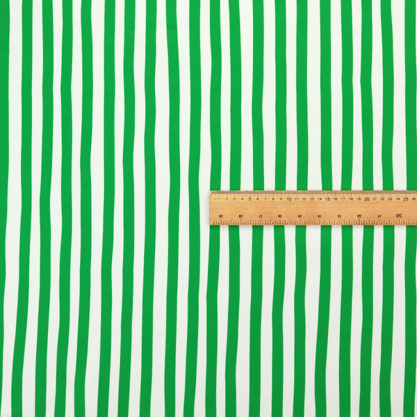 A white fabric patterned with vertical, hand-drawn green stripes that feature a slight, organic waviness.