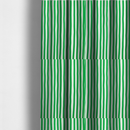 The fabric used to create these made-to-measure curtains is a white fabric patterned with vertical, hand-drawn green stripes that feature a slight, organic waviness.