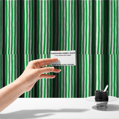 The fabric used to create these made-to-measure curtains is a white fabric patterned with vertical, hand-drawn green stripes that feature a slight, organic waviness.