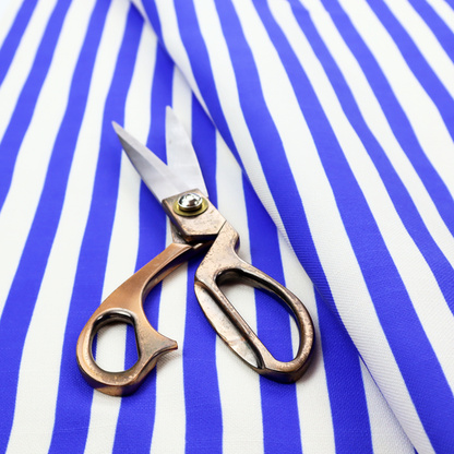 A white fabric patterned with vertical, hand-drawn blue stripes that feature a slight, organic waviness.   