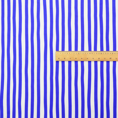 A white fabric patterned with vertical, hand-drawn blue stripes that feature a slight, organic waviness.   