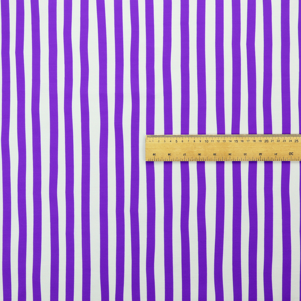 A white fabric patterned with vertical, hand-drawn purple stripes that feature a slight, organic waviness.