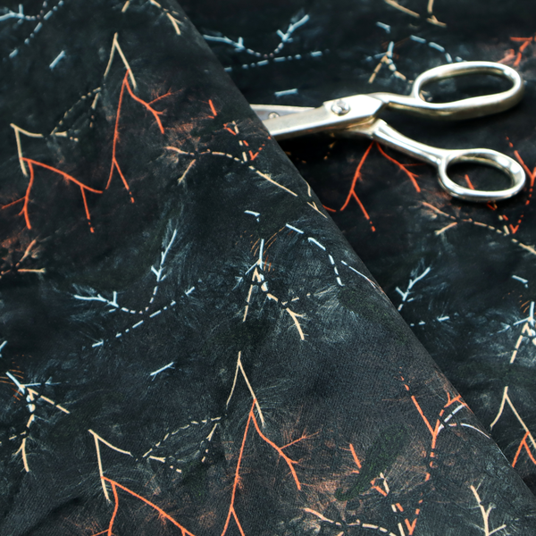 This fabric features an abstract, wolf-like motif, made up of orange and white lines on a dark, forest inspired fabric.