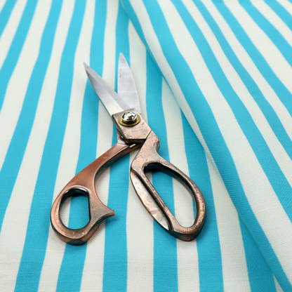 A white fabric patterned with vertical, hand-drawn light blue stripes that feature a slight, organic waviness.