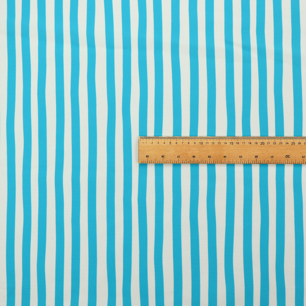 A white fabric patterned with vertical, hand-drawn light blue stripes that feature a slight, organic waviness.