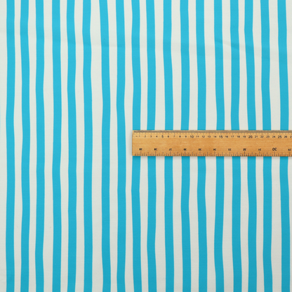 A white fabric patterned with vertical, hand-drawn light blue stripes that feature a slight, organic waviness.