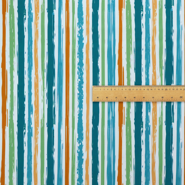 A white fabric patterned with multi-coloured vertical, hand-drawn stripes in teal, green, blue, and orange with a slight, organic waviness.