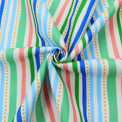A white fabric patterned with vertical, hand-drawn multi-coloured stripes in green, blue, pink, and light blue alongside dotted lines that feature an organic waviness.
