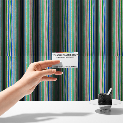 The fabric used to create these made-to-measure curtains is a white fabric patterned with vertical, hand-drawn multi-coloured stripes in green, blue, pink, and light blue alongside dotted lines that feature an organic waviness.
