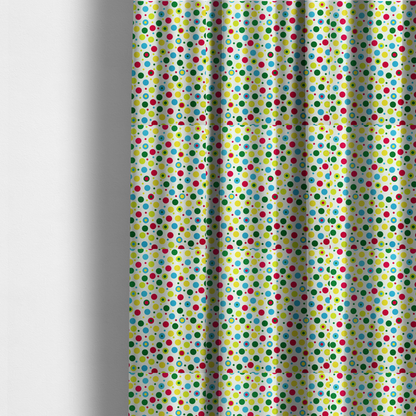 The fabric used to create these made-to-measure curtains is a playful fabric pattern featuring scattered polka dots and concentric circles in various sizes and colours, including pink, blue, green, yellow, and lime on a white background.