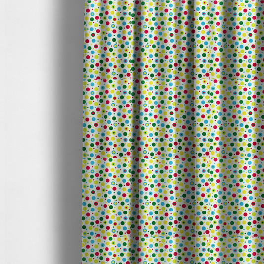 The fabric used to create these made-to-measure curtains is a playful fabric pattern featuring scattered polka dots and concentric circles in various sizes and colours, including pink, blue, green, yellow, and lime on a white background.