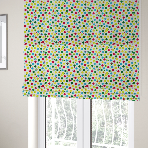 The fabric used to create these Roman blinds is a playful fabric pattern featuring scattered polka dots and concentric circles in various sizes and colours, including pink, blue, green, yellow, and lime on a white background.