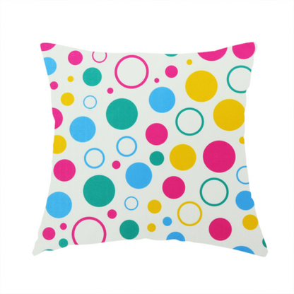 The fabric used to create this handmade cushion is a fun and colourful fabric pattern featuring random solid and hollow polka dots in pink, teal, yellow, and blue on a white background.