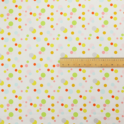 A subtle fabric pattern featuring scattered pastel and bright polka dots in shades of yellow, orange, light green, grey, and soft blue on a white background.